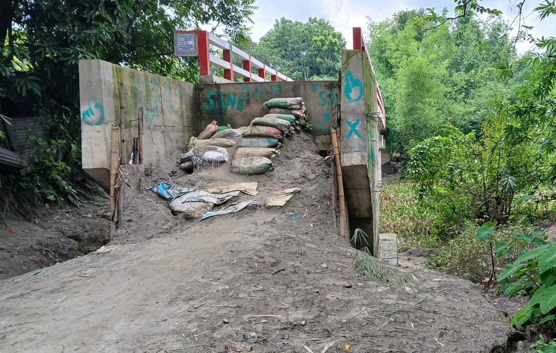 The Tk 90 lakh bridge over the Louhajang River in Tangail Laujana village remains unusable due to the lack of connecting roads, causing daily suffering for residents of 30 nearby villages.